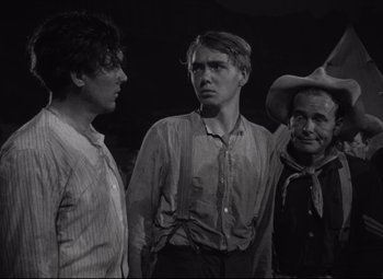 Movie still from “Rio Grande” (1950), directed by John Ford – A group of men standing next to each other; Medium shot, Over the shoulder angle