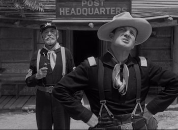 Movie still from “Rio Grande” (1950), directed by John Ford – Two men dressed in old time western clothing; Medium shot, Low angle