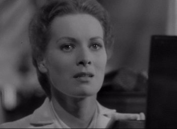 Movie still from “Rio Grande” (1950), directed by John Ford – A black - and - white photo of a woman looking at the camera; Close Up shot, Over the shoulder angle