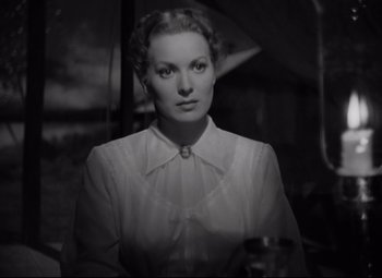 Movie still from “Rio Grande” (1950), directed by John Ford – A black - and - white photo of a woman in a white dress; Close Up shot, Low angle
