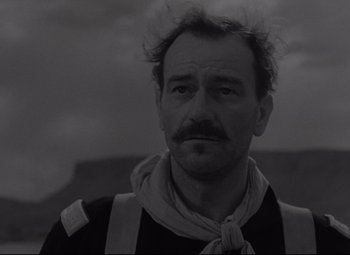 Movie still from “Rio Grande” (1950), directed by John Ford – A black and white photo of a man with a mustache; Close Up shot, Low angle