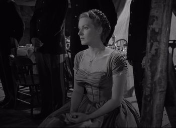 Movie still from “Rio Grande” (1950), directed by John Ford – A black and white photo of a woman in a dress; Medium shot, Low angle