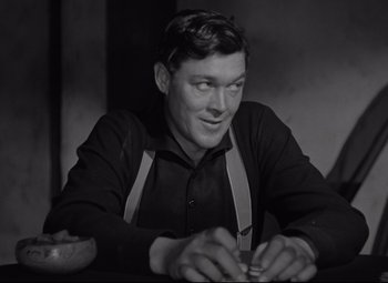 Movie still from “Rio Grande” (1950), directed by John Ford – A black and white photo of a man holding a knife; Medium shot, Low angle