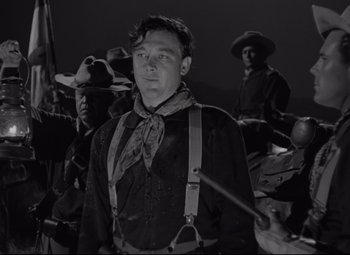 Movie still from “Rio Grande” (1950), directed by John Ford – A black and white photo of a man in a cowboy outfit; Medium shot, Low angle