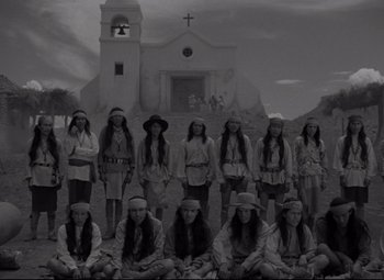 Movie still from “Rio Grande” (1950), directed by John Ford – A black and white photo of a group of people in front of a church; Wide shot, High angle