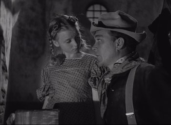 Movie still from “Rio Grande” (1950), directed by John Ford – A man and a little girl are looking at each other; Medium shot, Low angle