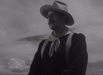 Movie still from “Rio Grande” (1950), directed by John Ford – A black and white photo of a man wearing a cowboy hat; Medium shot, Low angle