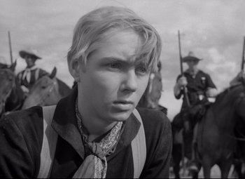 Movie still from “Rio Grande” (1950), directed by John Ford – A young man in a black and white photo with horses; Close Up shot, Low angle
