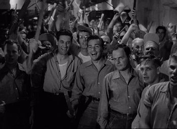 Movie still from “Riot in Cell Block 11” (1954), directed by Don Siegel – A black and white photo of a group of men; Medium shot, High angle