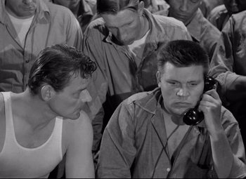 Movie still from “Riot in Cell Block 11” (1954), directed by Don Siegel – A group of men standing next to each other; Medium shot, High angle