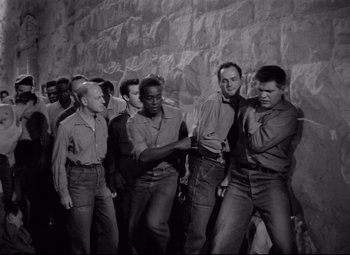 Movie still from “Riot in Cell Block 11” (1954), directed by Don Siegel – Black and white photograph of a group of men dancing; Medium shot, High angle