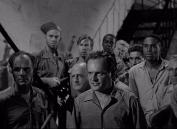 Movie still from “Riot in Cell Block 11” (1954), directed by Don Siegel – A black and white photo of a group of men; Medium shot, Low angle