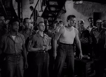 Movie still from “Riot in Cell Block 11” (1954), directed by Don Siegel – Black and white photograph of men standing in front of a fire hydrant; Medium shot, Low angle