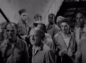 Movie still from “Riot in Cell Block 11” (1954), directed by Don Siegel – A black and white photo of a group of men; Medium shot, High angle