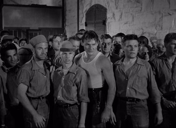 Movie still from “Riot in Cell Block 11” (1954), directed by Don Siegel – Black and white photograph of a group of men; Medium shot, Low angle