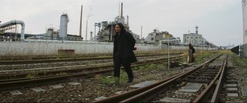 Movie still from “Ritual” (2000), directed by Hideaki Anno – A person walking on train tracks next to railroad tracks; Wide shot, Low angle
