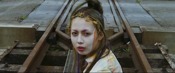 Movie still from “Ritual” (2000), directed by Hideaki Anno – A young woman with bright make - up on her face; Close Up shot, Low angle