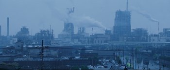 Movie still from “Ritual” (2000), directed by Hideaki Anno – A factory with a lot of smoke coming out of it; Extreme Wide shot, Low angle