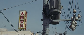 Movie still from “Ritual” (2000), directed by Hideaki Anno – A street light with wires hanging from it; Extreme Wide shot, Low angle