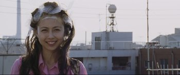 Movie still from “Ritual” (2000), directed by Hideaki Anno – A young woman wearing a pink shirt standing in front of a ship; Close Up shot, Low angle
