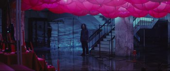 Movie still from “Ritual” (2000), directed by Hideaki Anno – A man standing in front of a staircase with pink balloons hanging from the ceiling; Wide shot, High angle