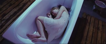 Movie still from “Ritual” (2000), directed by Hideaki Anno – A woman laying in a bath tub with her head on the floor; Medium shot, Overhead angle