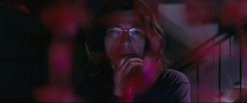 Movie still from “Ritual” (2000), directed by Hideaki Anno – A man with glasses is looking at the camera; Close Up shot, Low angle