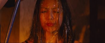 Movie still from “Ritual” (2000), directed by Hideaki Anno – A woman with long black hair is covered in oil; Close Up shot, Low angle