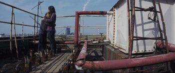 Movie still from “Ritual” (2000), directed by Hideaki Anno – A man standing on top of an oil rig looking out over the water; Wide shot, Low angle