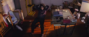 Movie still from “Ritual” (2000), directed by Hideaki Anno – A man sitting on the floor in a room; Wide shot, High angle