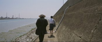 Movie still from “Ritual” (2000), directed by Hideaki Anno – Two women are walking down the stairs to the water; Wide shot, Low angle