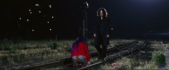 Movie still from “Ritual” (2000), directed by Hideaki Anno – A woman standing next to another woman on a train track; Wide shot, Low angle