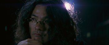 Movie still from “Ritual” (2000), directed by Hideaki Anno – A person with long black hair; Close Up shot, Low angle