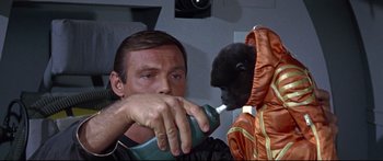 Movie still from “Robinson Crusoe on Mars” (1964), directed by Byron Haskin – A man holding a phone to a gorilla's mouth; Close Up shot, Over the shoulder angle
