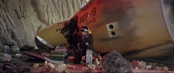 Movie still from “Robinson Crusoe on Mars” (1964), directed by Byron Haskin – A man in a space suit sitting in front of an airplane; Wide shot, Low angle