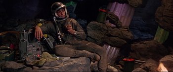 Movie still from “Robinson Crusoe on Mars” (1964), directed by Byron Haskin – A man sitting on the ground wearing a space helmet; Medium shot, High angle