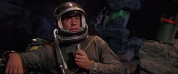 Movie still from “Robinson Crusoe on Mars” (1964), directed by Byron Haskin – A man in a space suit holding a screwdriver; Medium shot, Low angle