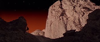 Movie still from “Robinson Crusoe on Mars” (1964), directed by Byron Haskin – A man standing on top of a rock formation; Extreme Wide shot, Low angle