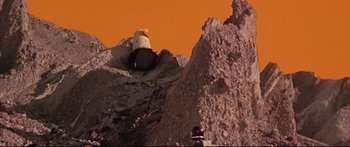 Movie still from “Robinson Crusoe on Mars” (1964), directed by Byron Haskin – An image of a person climbing a rock wall; Extreme Wide shot, Low angle