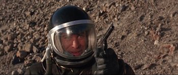 Movie still from “Robinson Crusoe on Mars” (1964), directed by Byron Haskin – A man in a space suit holding a gun; Close Up shot, Overhead angle