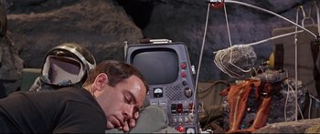 Movie still from “Robinson Crusoe on Mars” (1964), directed by Byron Haskin – A man sleeping next to an old television set; Medium shot, High angle