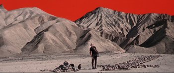 Movie still from “Robinson Crusoe on Mars” (1964), directed by Byron Haskin – A man standing in front of a red sky and a mountain; Extreme Wide shot, Low angle