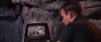 Movie still from “Robinson Crusoe on Mars” (1964), directed by Byron Haskin – A man sitting in front of an old television; Close Up shot, Over the shoulder angle