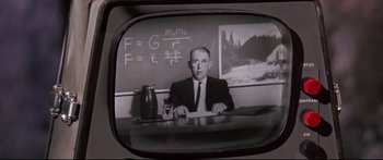 Movie still from “Robinson Crusoe on Mars” (1964), directed by Byron Haskin – An older man sitting at a desk in front of a chalkboard; Close Up shot, Low angle