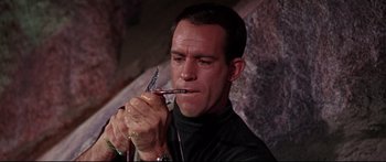 Movie still from “Robinson Crusoe on Mars” (1964), directed by Byron Haskin – A man holding a pair of scissors in his mouth; Close Up shot, Low angle