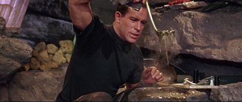 Movie still from “Robinson Crusoe on Mars” (1964), directed by Byron Haskin – A man in a black shirt is working on something; Medium shot, High angle