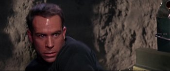 Movie still from “Robinson Crusoe on Mars” (1964), directed by Byron Haskin – A person in a black shirt looking at the camera; Close Up shot, Low angle