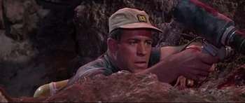 Movie still from “Robinson Crusoe on Mars” (1964), directed by Byron Haskin – A person wearing a hat near some rocks; Close Up shot, High angle