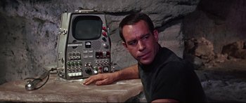 Movie still from “Robinson Crusoe on Mars” (1964), directed by Byron Haskin – A man sitting in front of an old television set; Close Up shot, High angle