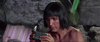 Movie still from “Robinson Crusoe on Mars” (1964), directed by Byron Haskin – A man with long hair looking at a cell phone; Close Up shot, Low angle